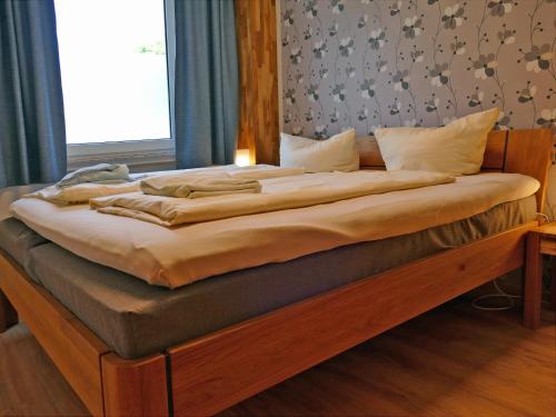 a large bed in a bedroom with a wooden frame at Am Maiglöckchenberg 19 in Ostseebad Karlshagen