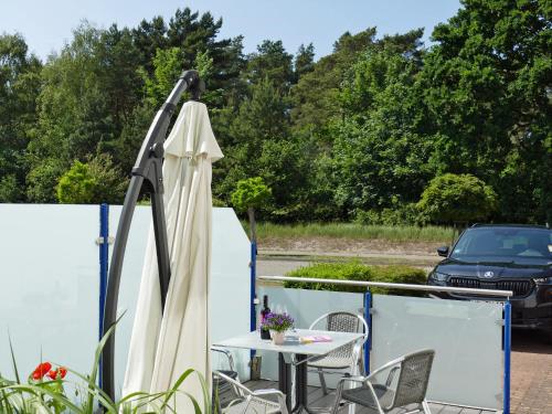 an umbrella and a table on a balcony with a car at Am Maiglöckchenberg 19 in Ostseebad Karlshagen