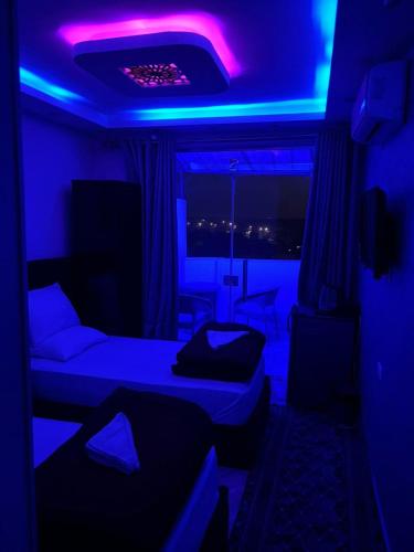 a room with two beds and a purple lighting at Abdin pyramids view in Cairo