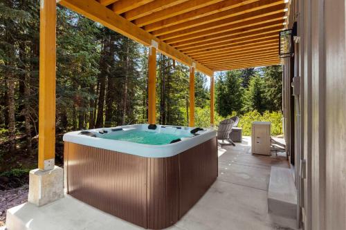 einen Whirlpool auf einer Terrasse eines Hauses in der Unterkunft 3 Br Sleep 8 Hot Tub Fire Pit Stunning Views in Government Camp