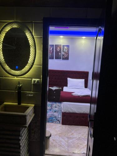 a room with a bed and a mirror and a sink at Abdin pyramids view in Cairo