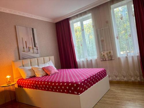 a bedroom with a bed with a red and white blanket at Vashlovani Sweet Home in Dedoplis Tskaro