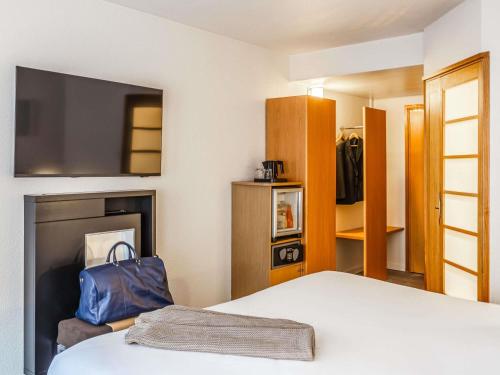 a hotel room with a bed and a tv at Novotel Lille Centre Gares in Lille
