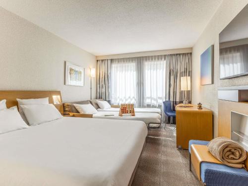 a hotel room with two beds and a fireplace at Novotel Lille Centre Gares in Lille