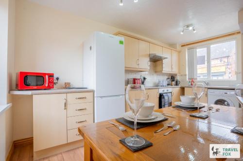 a kitchen with a wooden table and a white refrigerator at Ann's Home Near Alton Towers in Rocester