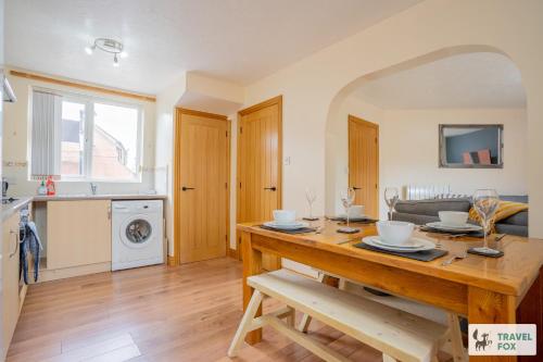 a kitchen and living room with a wooden dining table at Ann's Home Near Alton Towers in Rocester