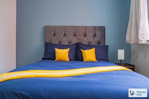 a blue bed with yellow pillows in a bedroom at Ann's Home Near Alton Towers in Rocester