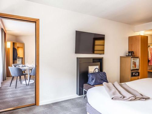a hotel room with a bed and a mirror at Novotel Lille Centre Gares in Lille
