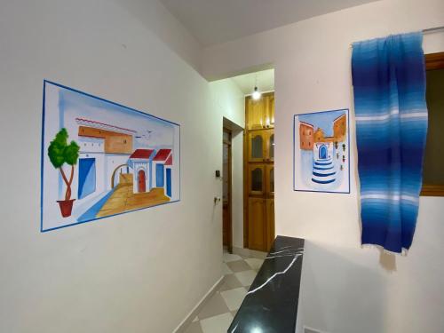 a room with paintings on the wall and a hallway at Ben House in Chefchaouene