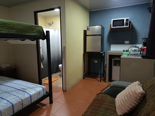 a room with a bunk bed and a kitchen with a refrigerator at Apartment-Pura Vida-wi-fi-6 people, AC- parking-river-garden in Fortuna