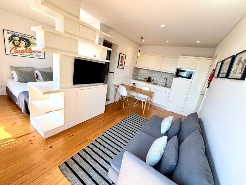 Una sala de estar con un sofá azul y una cocina. en Porto Cinema Apartments, en Oporto