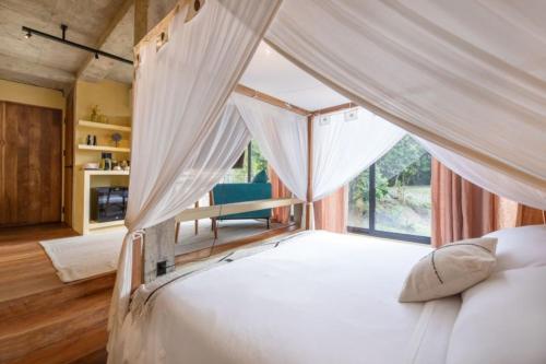 a bedroom with a canopy bed with a window at Sumba Lodge in Manuel Antonio