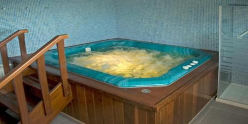a hot tub in a corner of a bathroom at Casa Buda Conors & Spa in Foz