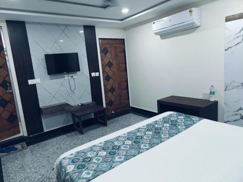 a hotel room with a bed and a television at Hotel jmm s14 in Udaipur