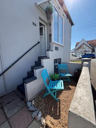 two blue chairs sitting outside of a house at 11B Beachside in Eastbourne