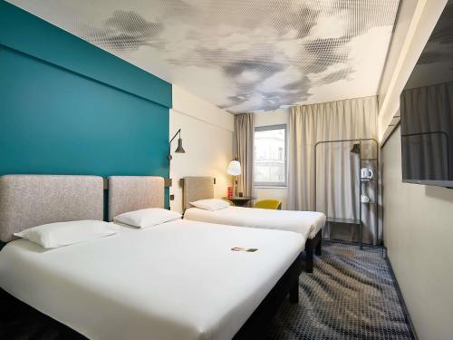 a room with three beds and a blue wall at Ibis Praha Wenceslas Square in Prague