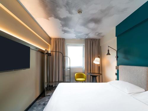 a hotel room with a bed and a yellow chair at Ibis Praha Wenceslas Square in Prague
