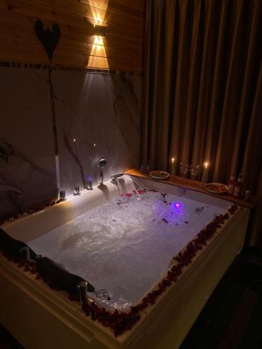 a bath tub filled with snow with purple lights at اكواخ القلعه in Ajloun