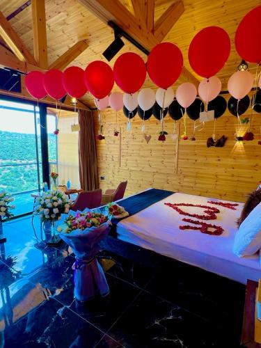 a room with a bed with red and white balloons at اكواخ القلعه in Ajloun
