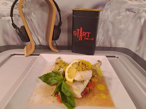 a plate of food with a fish with a lemon on it at Ibis Hotel Alicante in Alicante