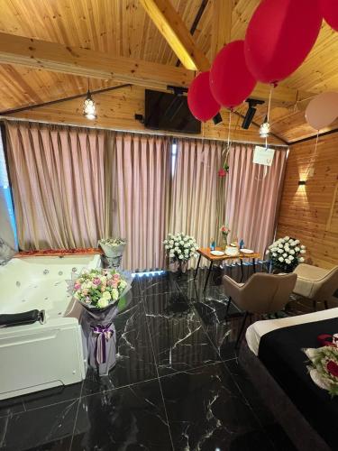 a room with red balloons and flowers in it at اكواخ القلعه in Ajloun