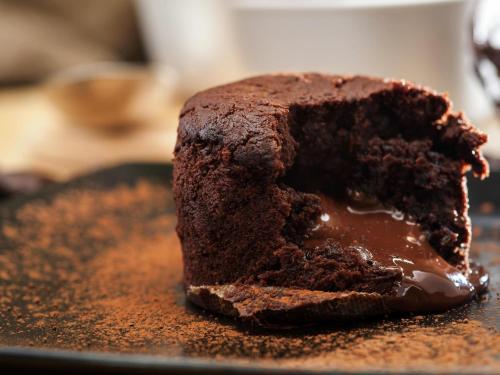a chocolate cake sitting on top of a black plate at Ibis Hotel Alicante in Alicante