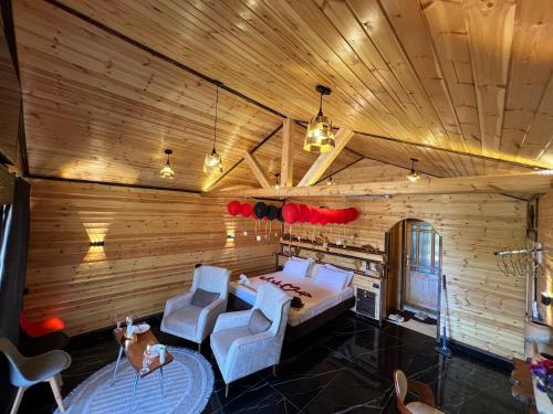 a bedroom with a bed and two chairs in a room at اكواخ القلعه in Ajloun