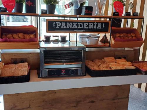 a bakery with bread and pastries on a counter at Ibis Hotel Alicante in Alicante