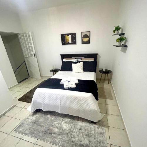 una camera da letto con un letto grande con lenzuola bianche di Pnz Loft a Petrolina