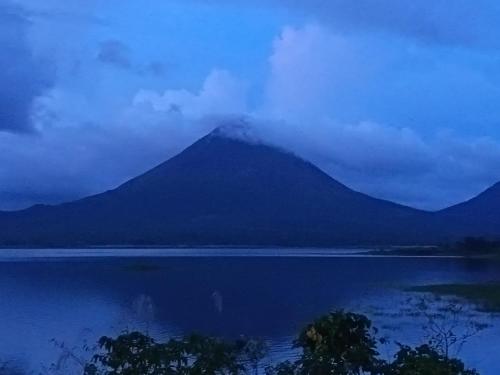 a mountain reflecting in a lake with a cloudy sky at Apartment-Pura Vida-wi-fi-6 people, AC- parking-river-garden in Fortuna