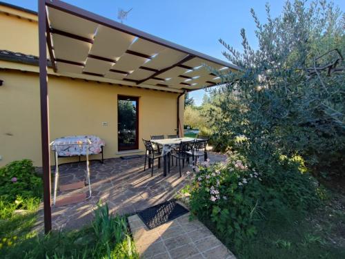 a patio with a table and chairs under a pergola at Casa Vacanze "Dimora Quercia" - Appartamento "Oliva" in Montefalco