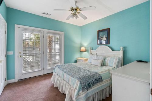 1 dormitorio azul con 1 cama y ventilador de techo en Charleston Court 10 Cherry Grove Small Dog Friendly, en Myrtle Beach