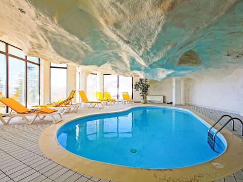 ein Swimmingpool in einem Raum mit einem Gemälde an der Decke in der Unterkunft Studio Le Bristol A25-31 by Interhome in Villars-sur-Ollon