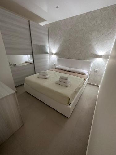 a white bedroom with a bed and a mirror at Lo duca luxury home in Cefalù