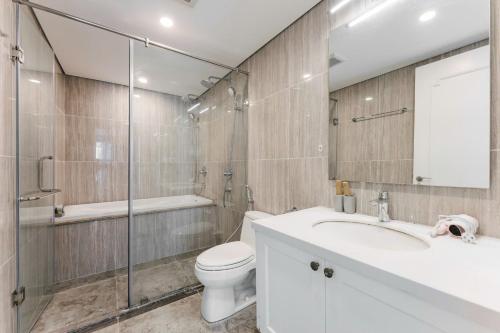 a bathroom with a toilet and a sink and a shower at D’Leroi Soleil - Westlake Suite & Apartment in Hanoi