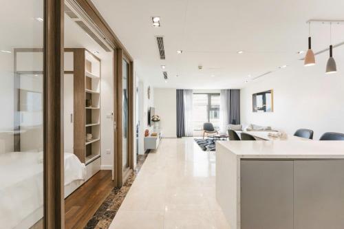 a kitchen and living room with white walls at D’Leroi Soleil - Westlake Suite & Apartment in Hanoi