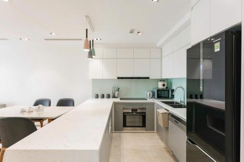 a kitchen with white cabinets and a counter top at D’Leroi Soleil - Westlake Suite & Apartment in Hanoi