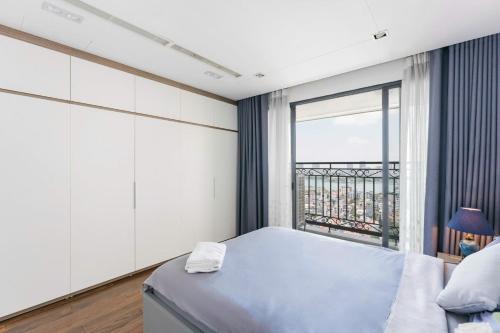 a bedroom with a bed and a large window at D’Leroi Soleil - Westlake Suite & Apartment in Hanoi