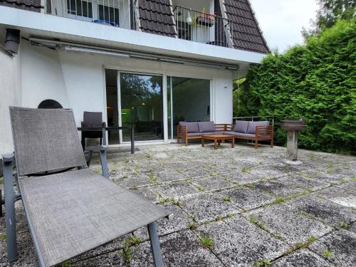 a patio with a chair and a table and a bench at Apartment Terrassenwohnung am See by Interhome in Neuglobsow