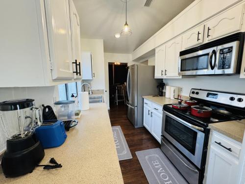 a kitchen with white cabinets and a black stove top oven at Fenced Yard • Fire pit • Fireplace • Pet Friendly in Wylie