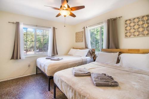 a bedroom with two beds and a ceiling fan at Casa Aloha Tropical Pool Beach 9 mins Games in Hollywood