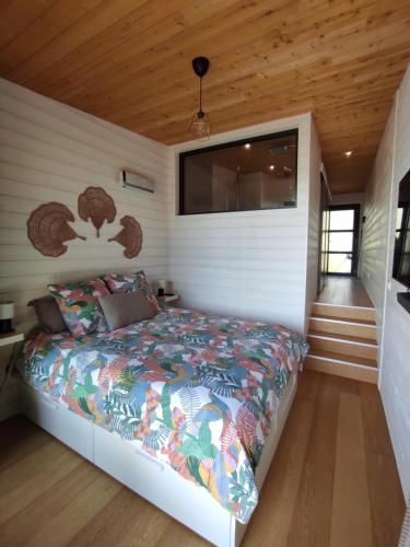a bedroom with a bed in a room with wooden ceilings at Chambre Perchée avec vue imprenable sur le lac de Lacanau in Lacanau