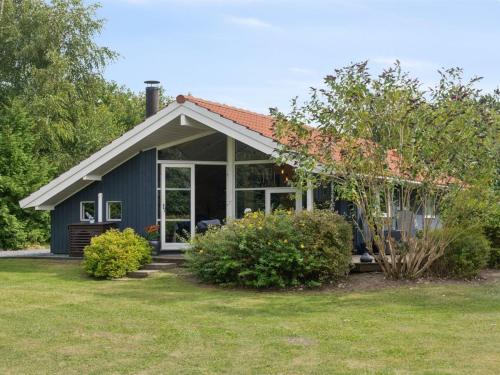 a small blue house with a garden and some bushes at Holiday Home Emelita - 175m from the sea by Interhome in Ågerup