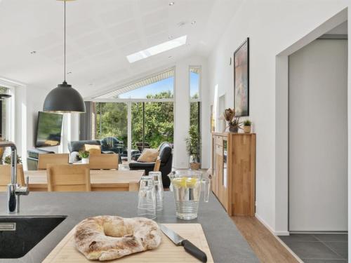 a kitchen and living room with a table with a knife at Holiday Home Troels - 945m from the sea by Interhome in Hornbæk
