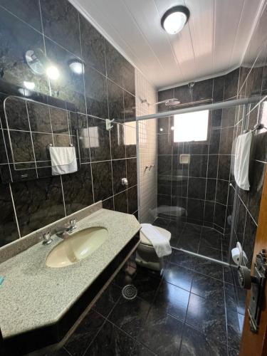 a bathroom with a sink and a shower at Paissandú Palace Hotel - Próximo às ruas 25 de Março, Sta Ifigênia e regiões do Brás e Bom Retiro in Sao Paulo