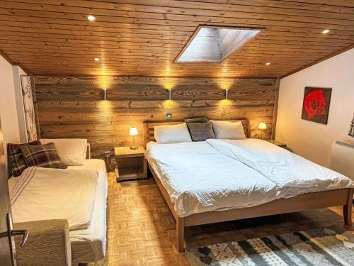 twee bedden in een slaapkamer met een houten muur bij Apartment Waddington by Interhome in Saalbach Hinterglemm