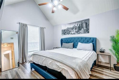 una camera con letto blu e ventilatore a soffitto di 3BR Home, 2mi Astros, 2mi Dynamo, King Bed, Med Center a Houston