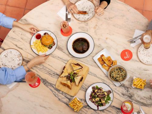 Una mesa con platos de comida encima en Esqina Cosmopolitan Lodge, en Lisboa