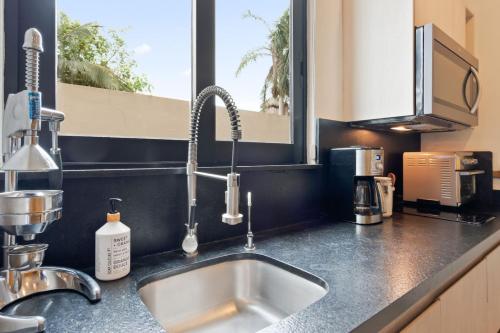 a kitchen counter with a sink and a window at Casa Armada Beachfront Condo with Pool in San Francisco