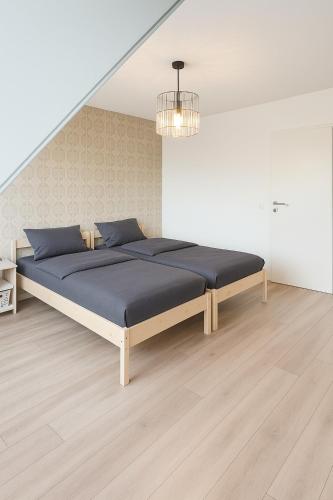 a bedroom with a large bed with blue pillows at Haus Auszeit in Cremlingen